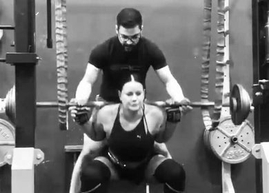 Personal trainer assisting client with squats at Leaha Toowoomba in Toowoomba City, Queensland, AU.