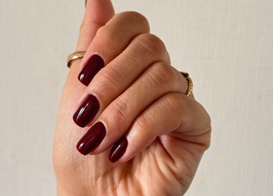 Uñas pintadas de rojo oscuro en Aura Nails, Ñuñoa, Región Metropolitana, CL.