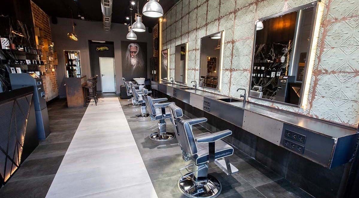 Interior elegante de Barberia nuevo stilo en Bogotá, D.C. con sillas modernas en fila y decoración vintage.