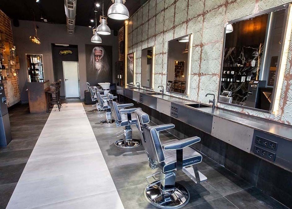 Interior moderno de Barberia nuevo stilo en Bogotá, D.c., CO, mostrando sillas y espejos iluminados.