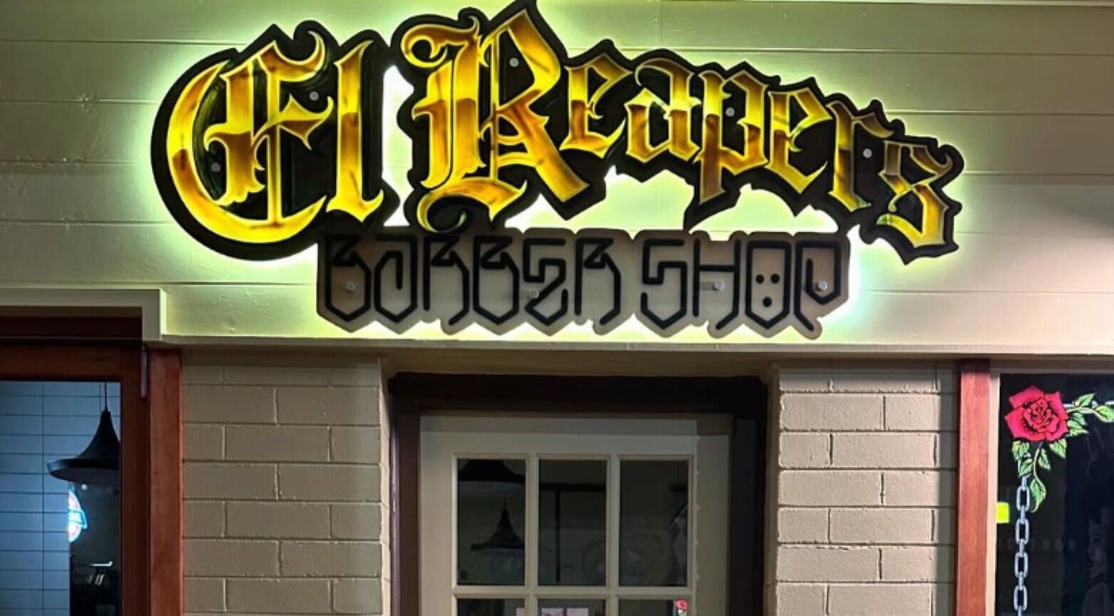 Vibrant El Reapers Barber Shop sign at Long Jetty, New South Wales, AU, glowing in bold neon colors.