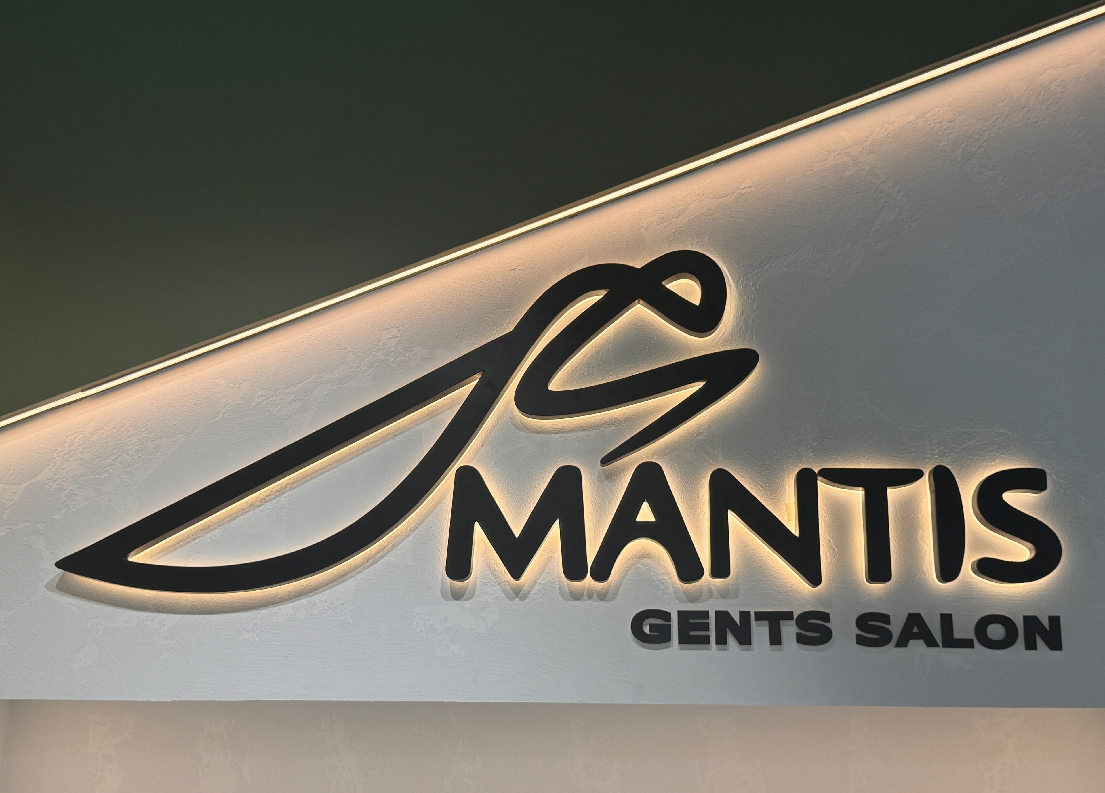 Illuminated logo of Mantis Gent’s Salon - Business Bay, Dubai, Dubai, AE, showcasing elegance and style.
