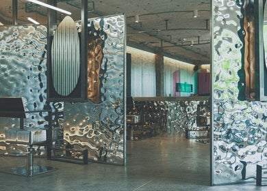 Interior moderno de Oculto Hair Club Marbella en San Pedro Alcántara, Andalucía, ES, con superficies metálicas brillantes.