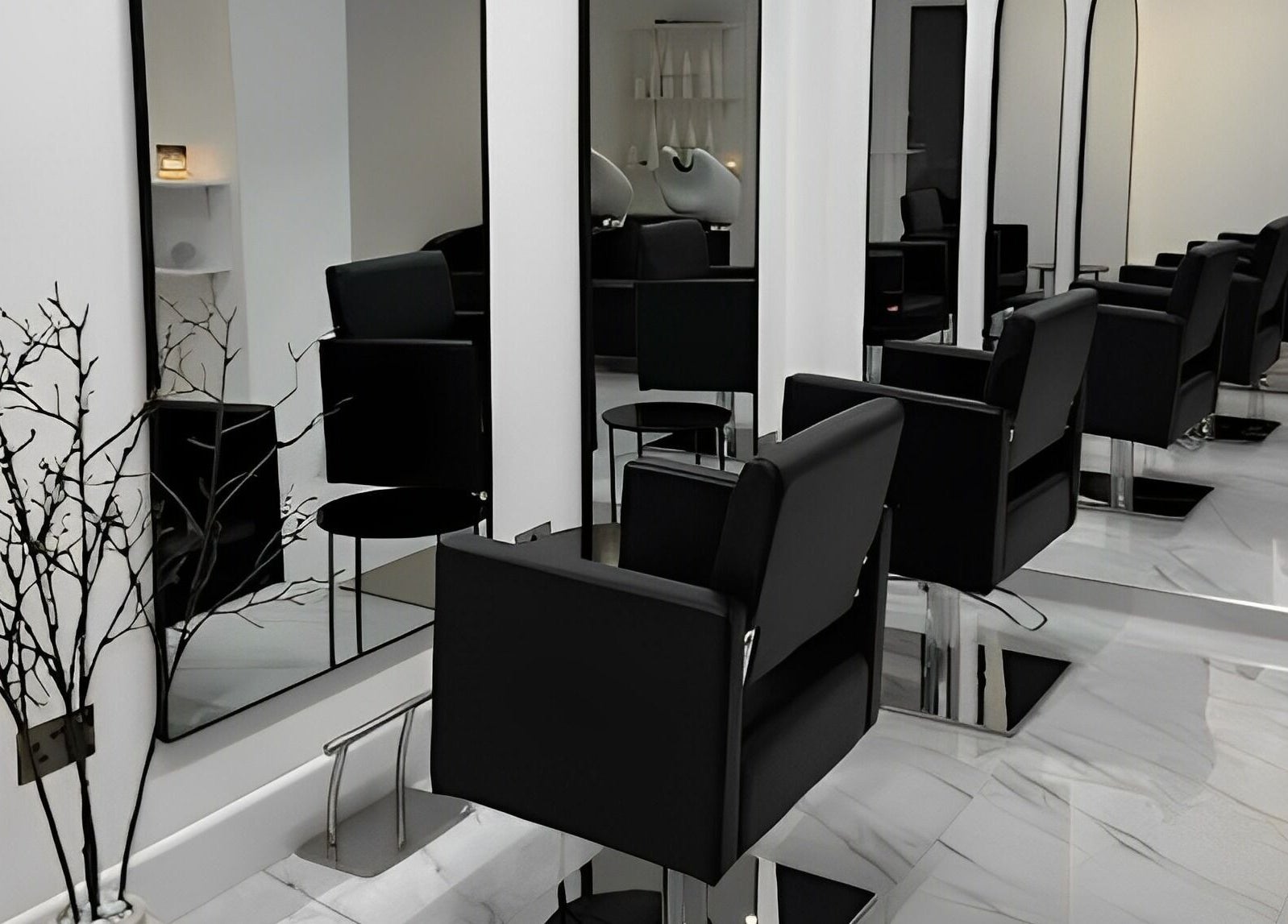 Elegant salon setup at STUDIO HONEY, Southampton, England, GB featuring sleek black chairs and large mirrors.