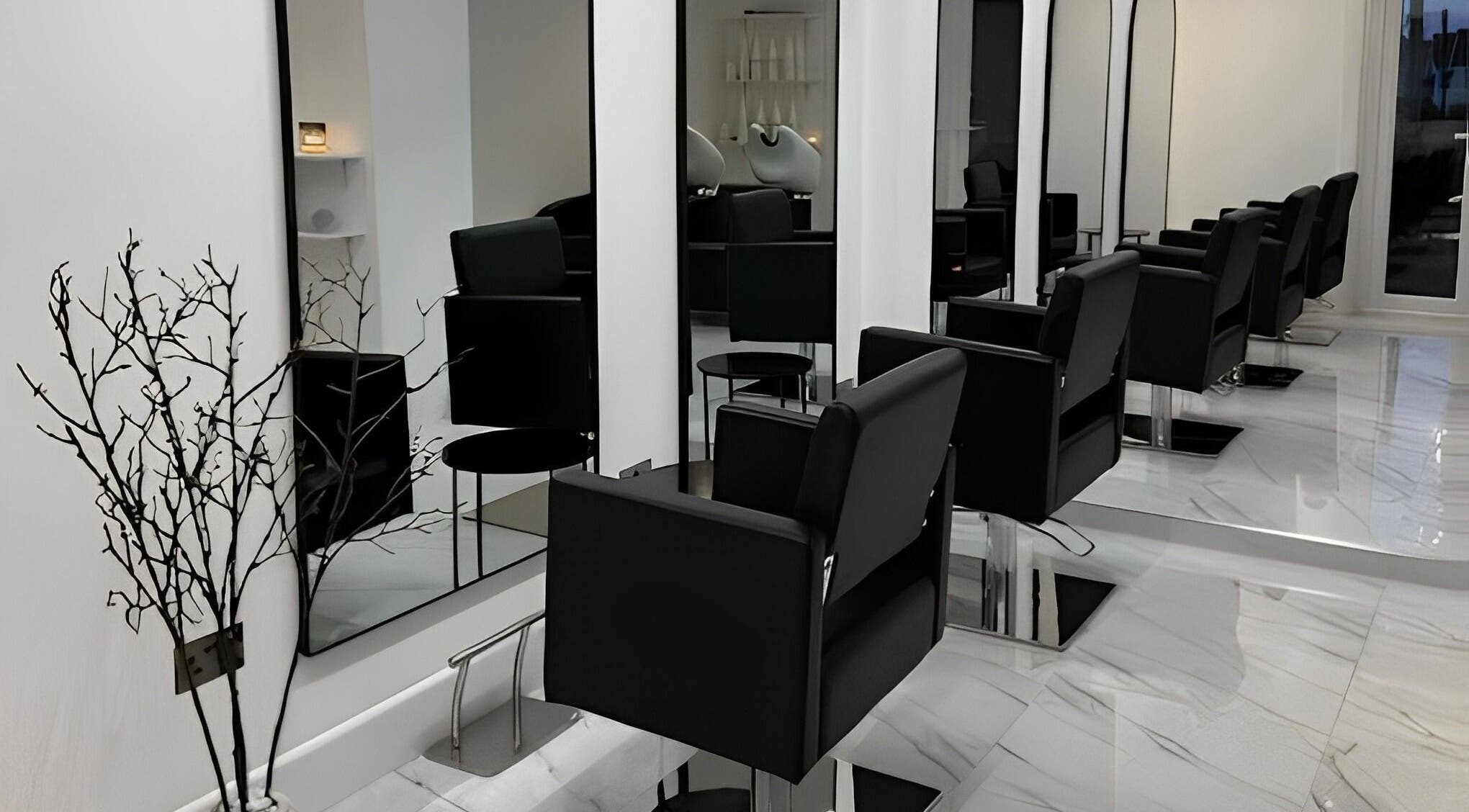 Elegant salon setup at STUDIO HONEY, Southampton, England, GB featuring sleek black chairs and large mirrors.