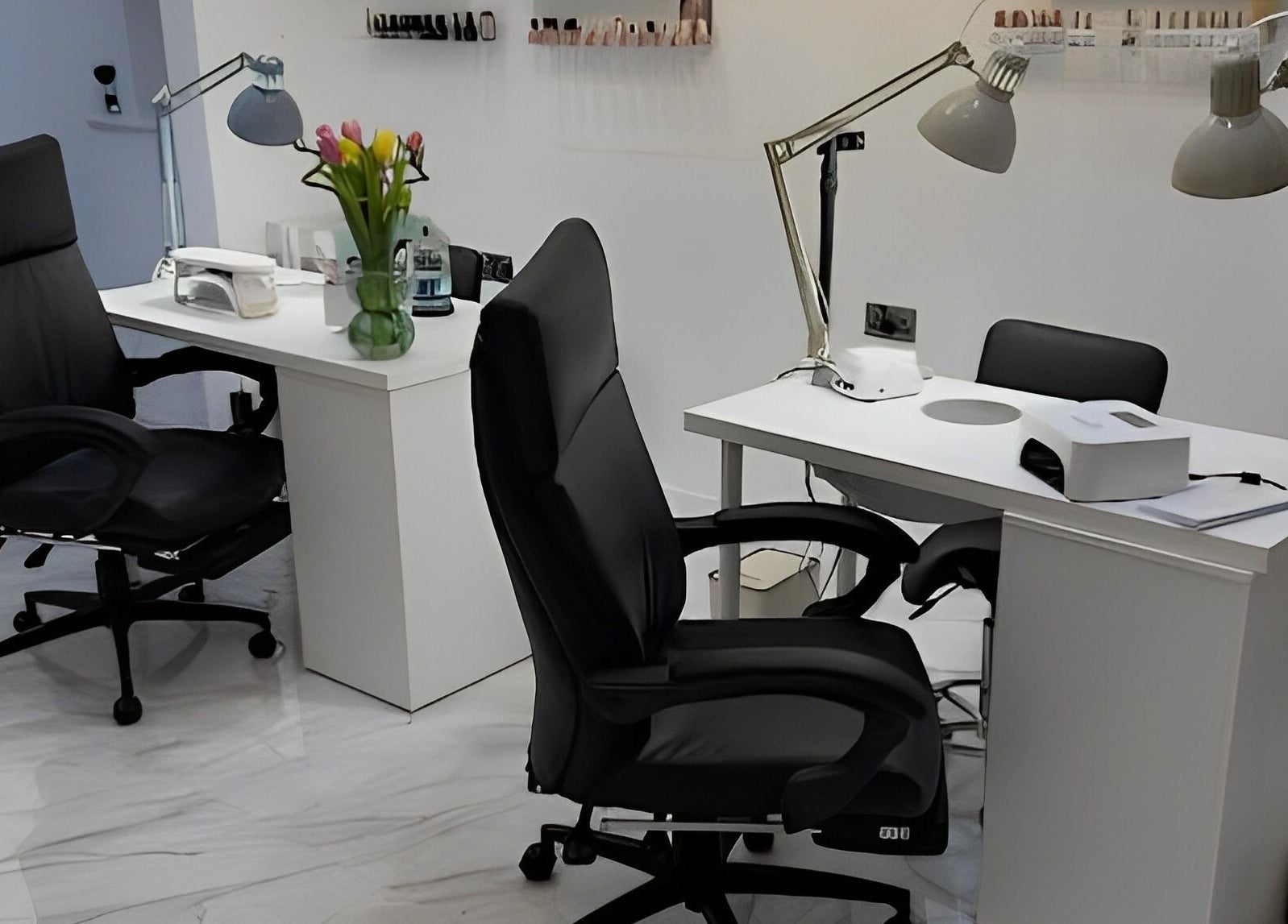 Chic manicure stations at STUDIO HONEY, Southampton, England, GB, featuring sleek black chairs and modern lighting.