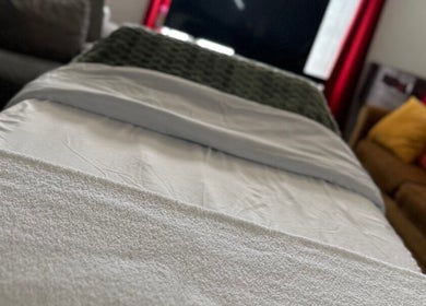 A cozy massage bed in Skintimacy Wellness and Esthetics, Phoenix, Arizona, US, with plush pillows and soft lighting.
