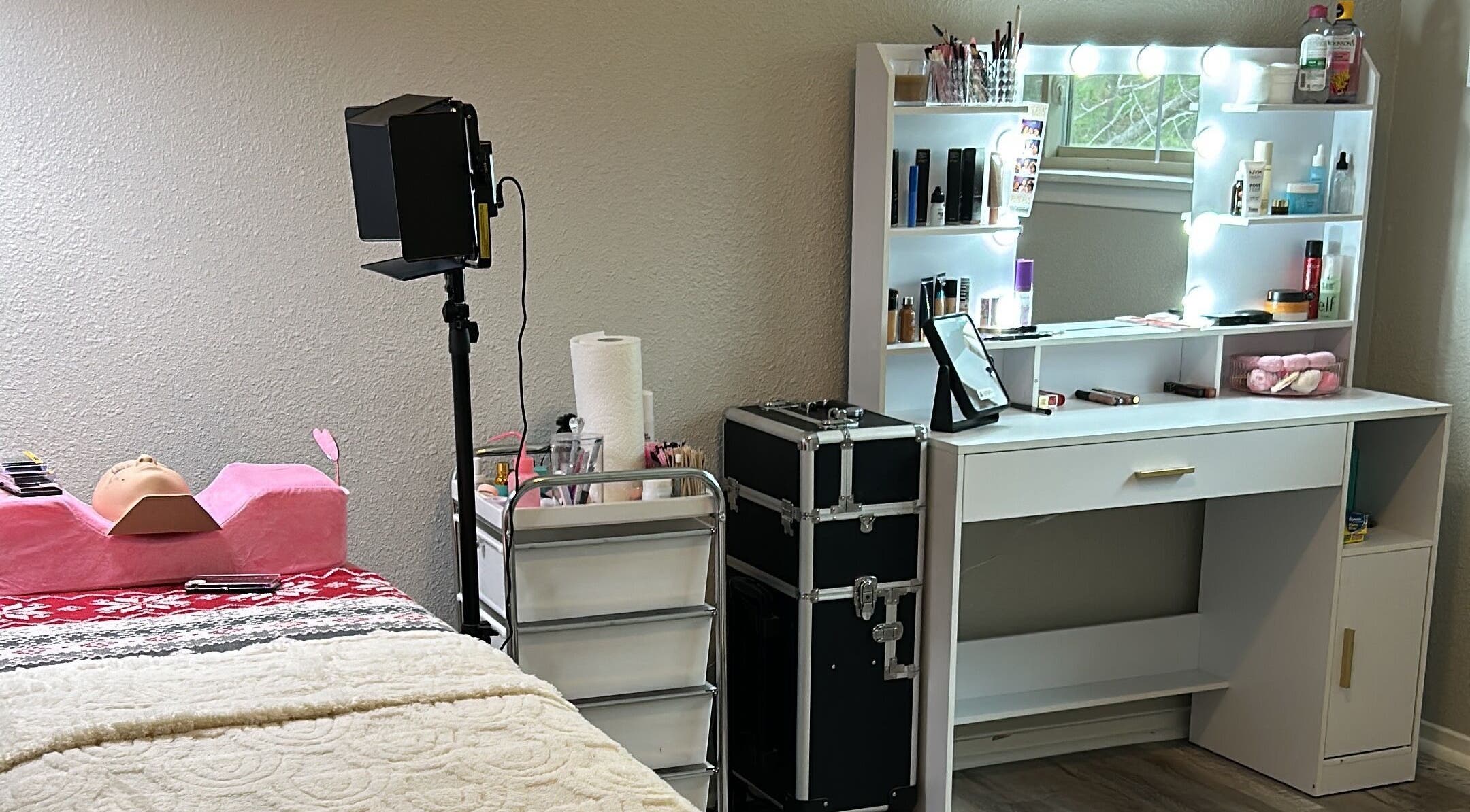 Beautybaeglam's chic beauty setup in Spring, Texas, US, featuring a vanity and a treatment bed.