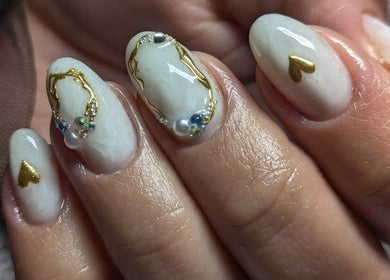 Élégant art des ongles à Vénuseum, Mouy, Hauts-de-France, FR, avec des accents dorés et perles.