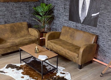 Stijlvolle zithoek bij Mitch Blends (South Side Barbers) in Beek, Limburg, NL met leren banken en moderne decor.