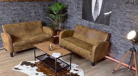 Stijlvolle zithoek bij Mitch Blends (South Side Barbers) in Beek, Limburg, NL met leren banken en moderne decor.
