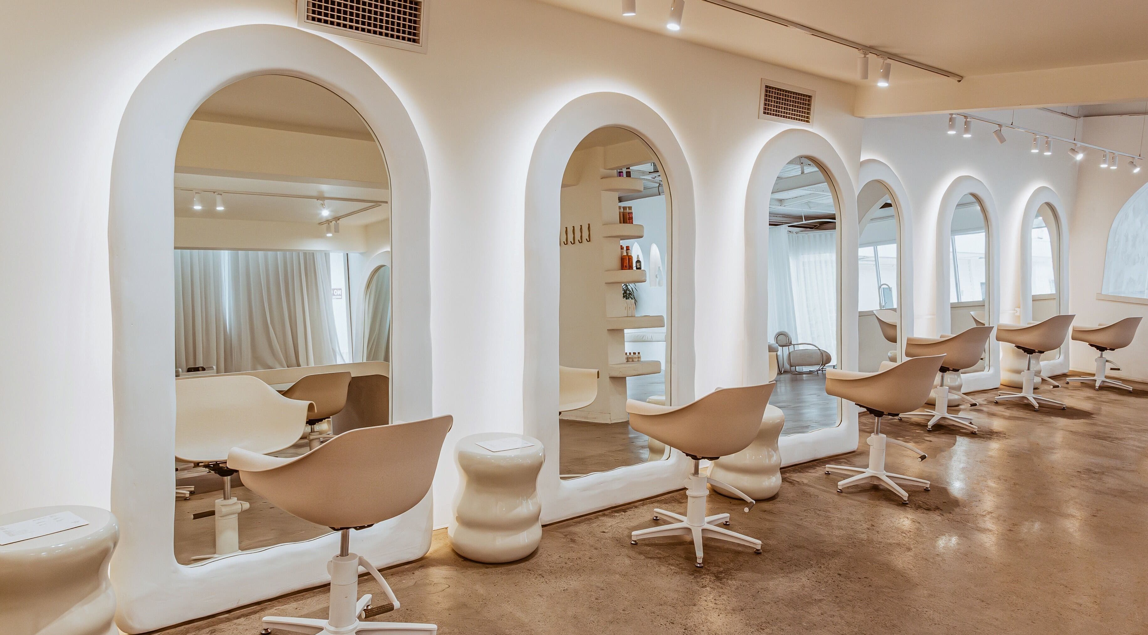 Stylish salon interior at Milly the Space in Palm Beach, Queensland, AU with arched mirrors and modern chairs.