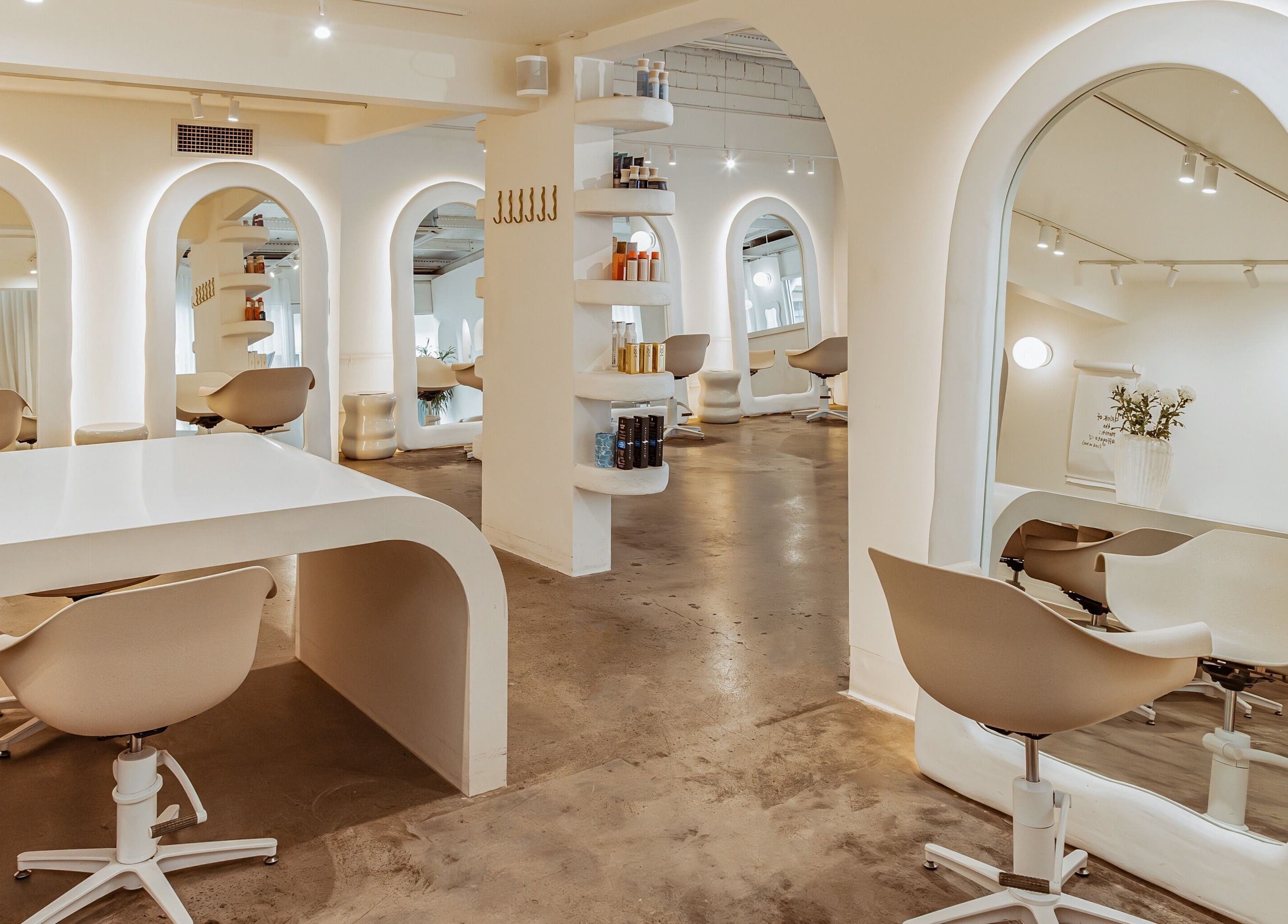 Chic interior of Milly the Space, Palm Beach, Queensland, AU featuring minimalist white decor and modern beauty chairs.
