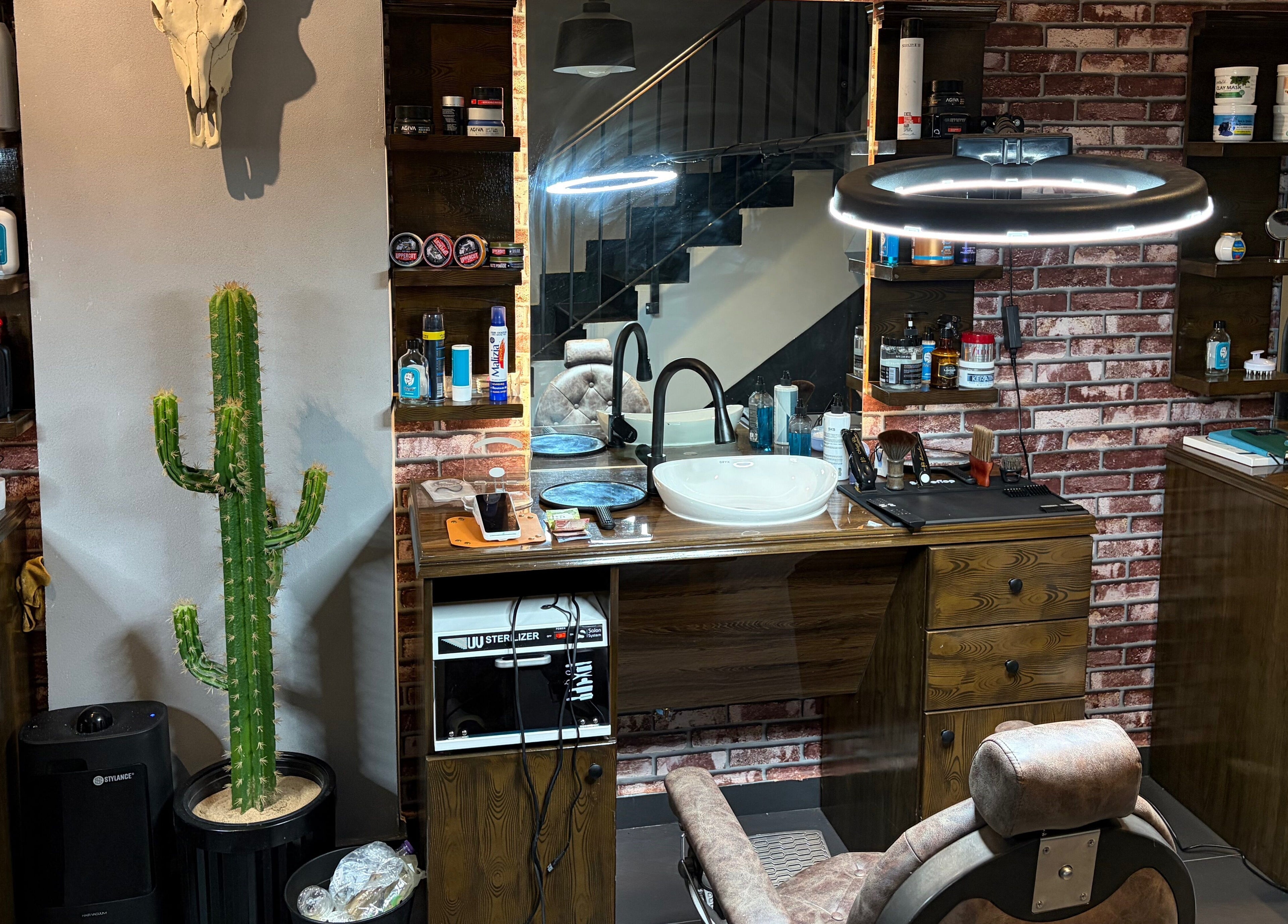 داخل صالون ذا دارك سِزر | The Dark Scissor Barber في ينبع، وهو مزين بصبار وديكور حجري.