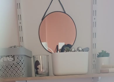 Étagère décorative avec miroir rond chez Sarah Naturopathe & Massages Bien-être, Grémonville, Normandie, FR.