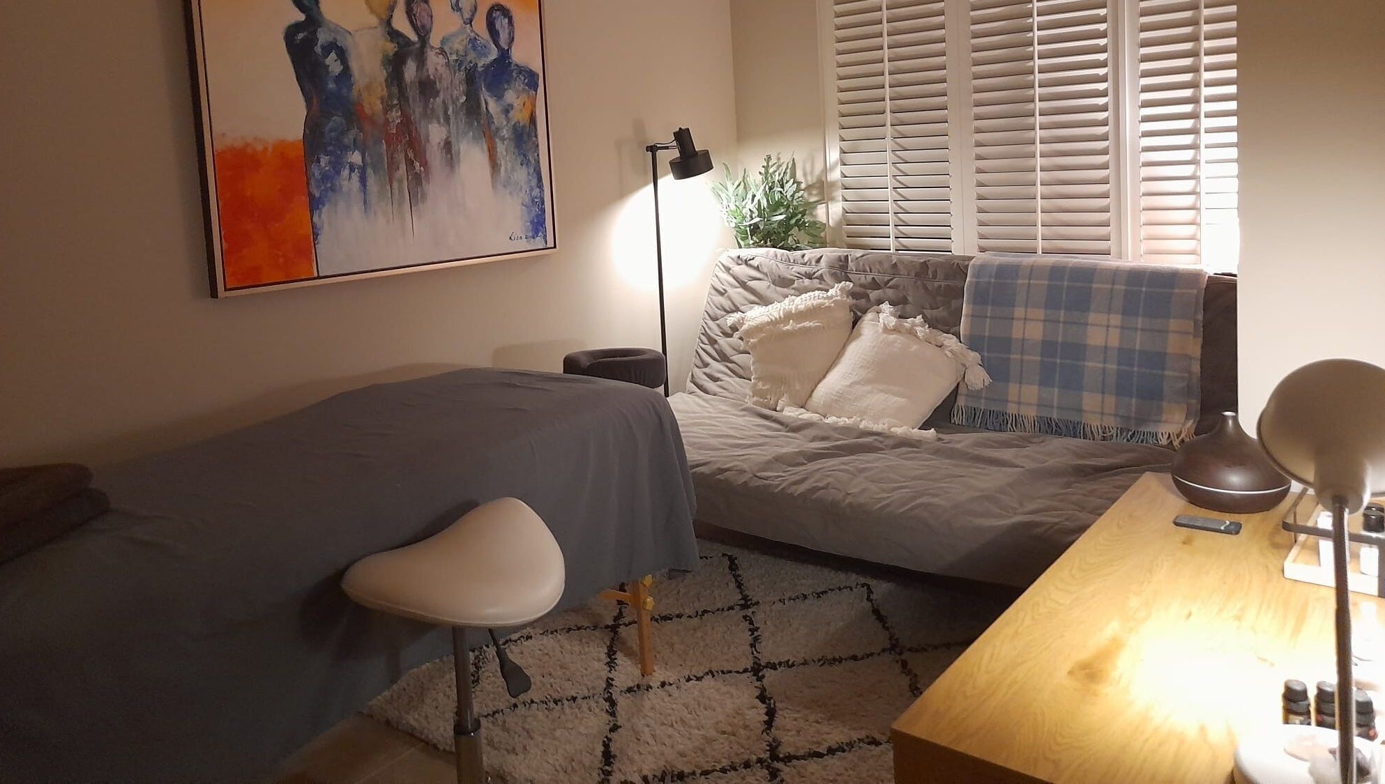 Gezellige ontspanningsruimte bij Eva Staal, Oegstgeest, Zuid-Holland, NL, met comfortabele bank en kunst aan de muur.