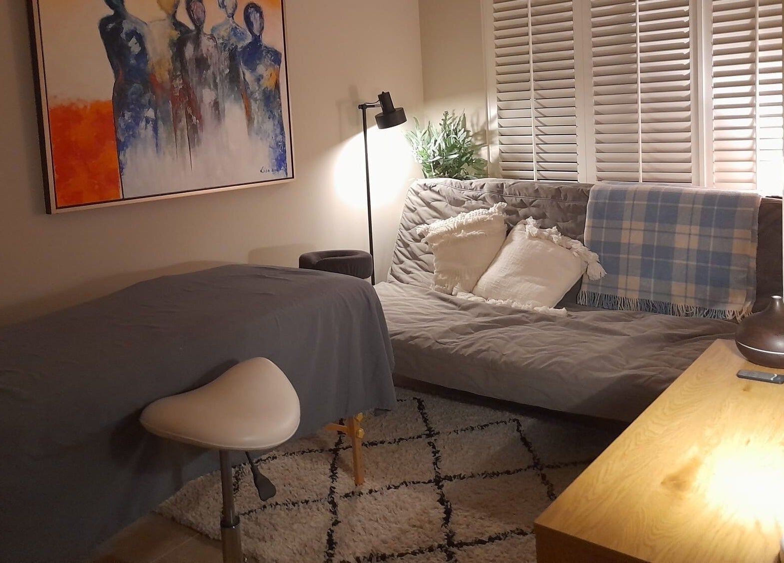 Gezellige ontspanningsruimte bij Eva Staal, Oegstgeest, Zuid-Holland, NL, met comfortabele bank en kunst aan de muur.