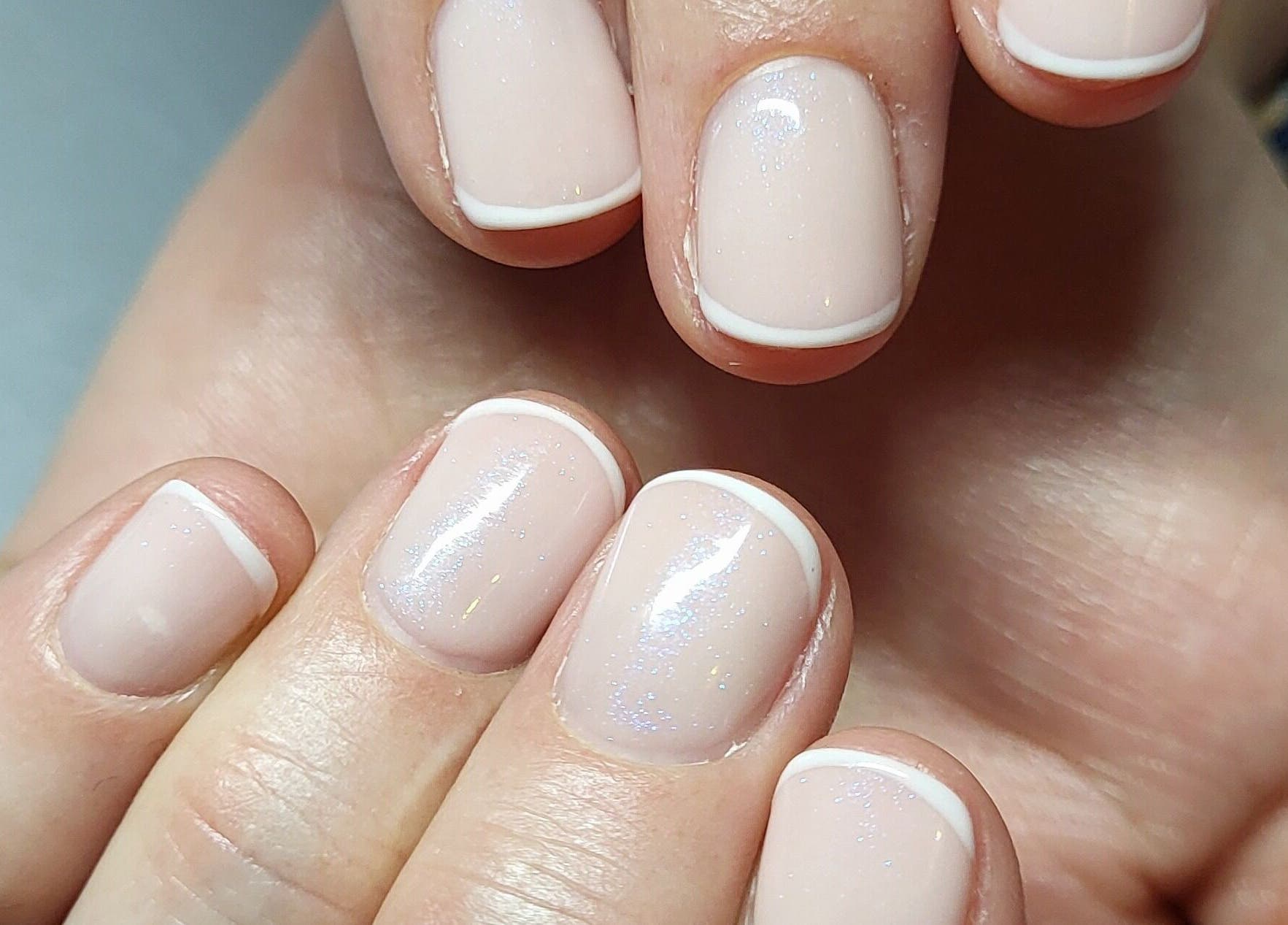 Nail art at Beautiques, Fleet, England, GB showcasing delicate French manicure style.