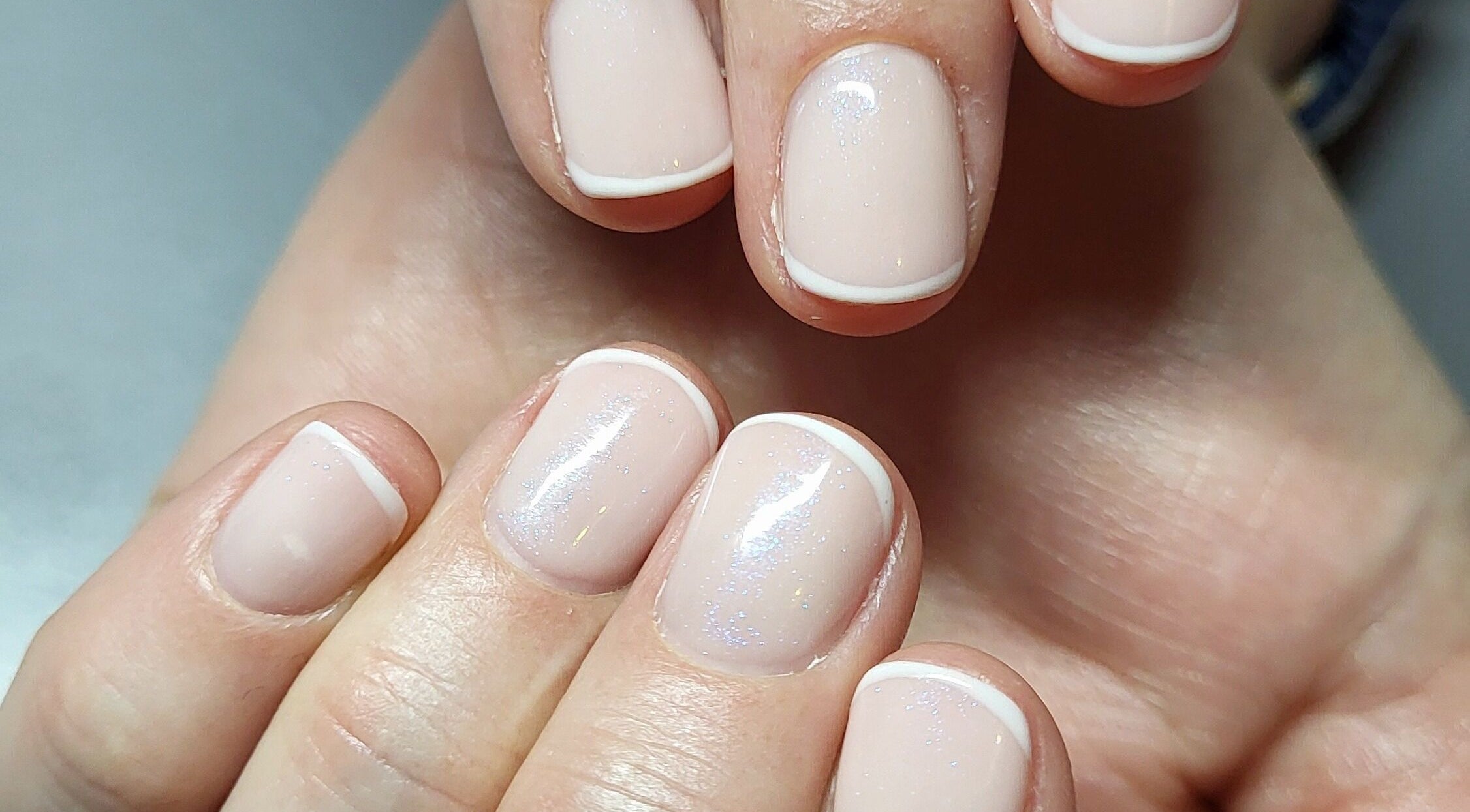 Nail art at Beautiques, Fleet, England, GB showcasing delicate French manicure style.