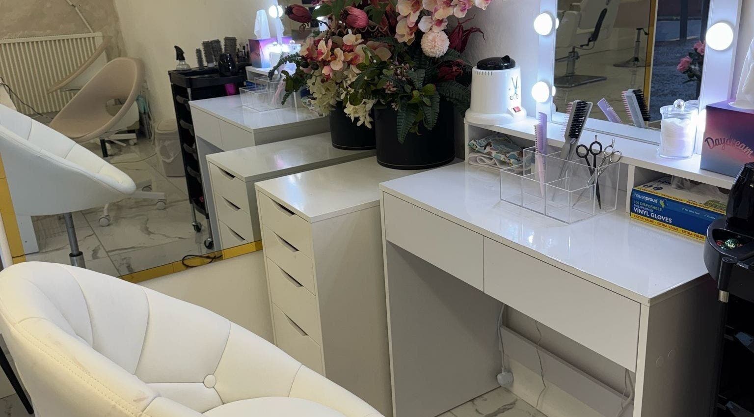 Chic vanity at Mona, Glasgow, Scotland, GB, with stylish chairs, mirrors, and vibrant flowers.