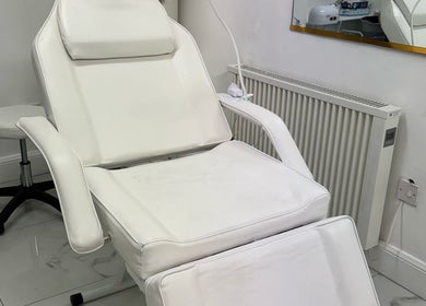 Comfortable white salon chair at Mona in Glasgow, Scotland, GB, offering relaxing wellness treatments.