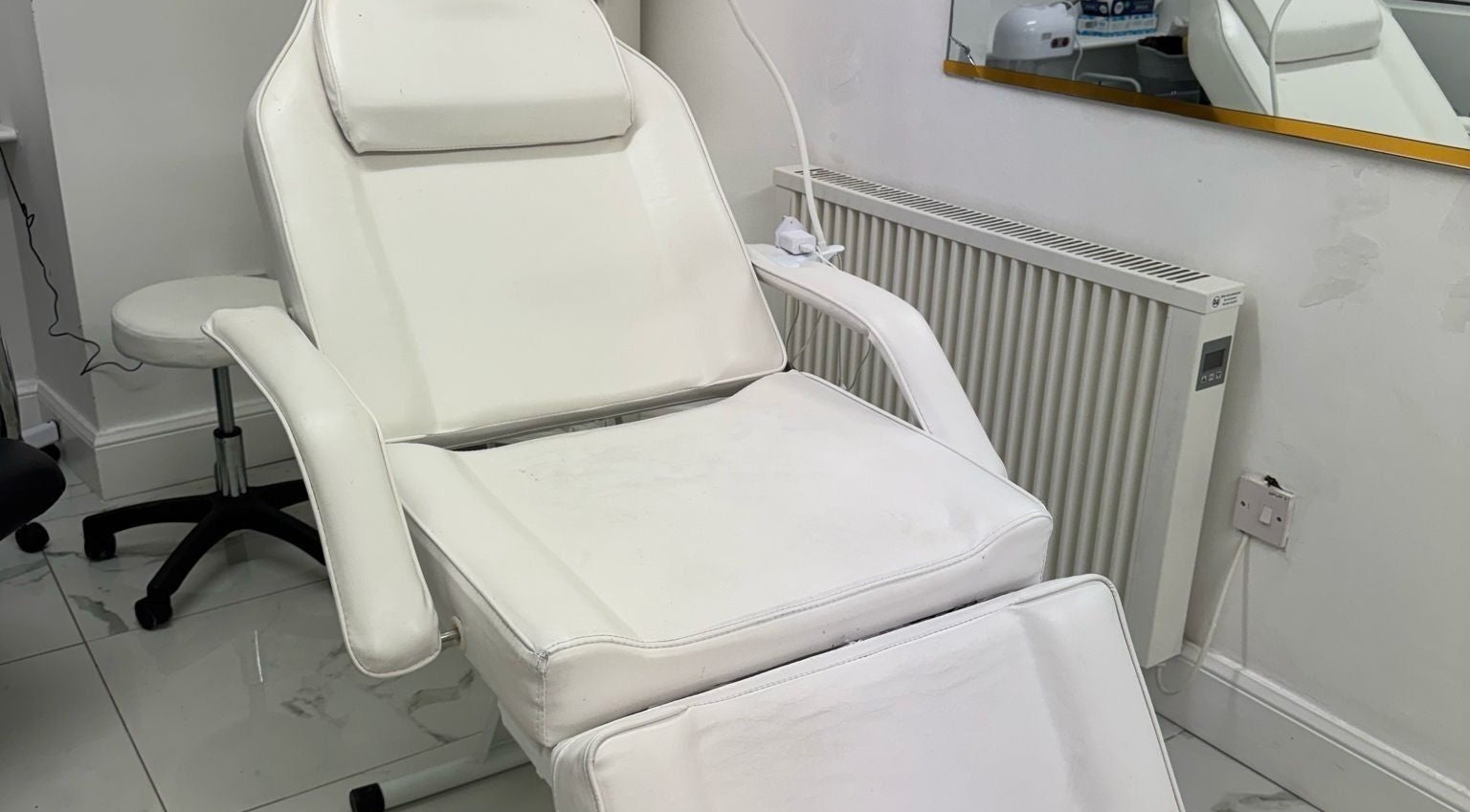 Comfortable white salon chair at Mona in Glasgow, Scotland, GB, offering relaxing wellness treatments.