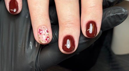Elegant floral gel nails by Gels by Eleanor in Glasgow, Scotland, GB. Featuring deep red polish and flower art.