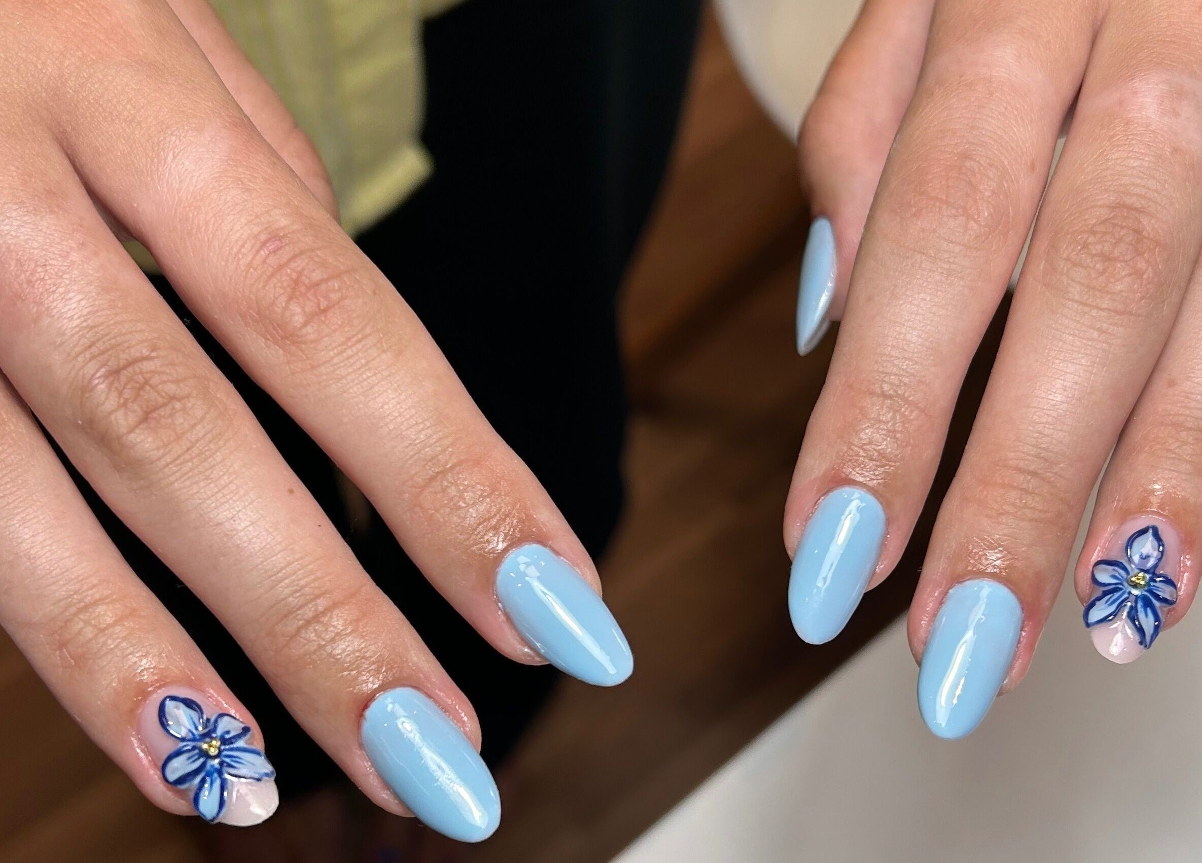 Unhas azuis com flores decorativas em Taissa Gomes Nails, Leiria, Leiria, PT.