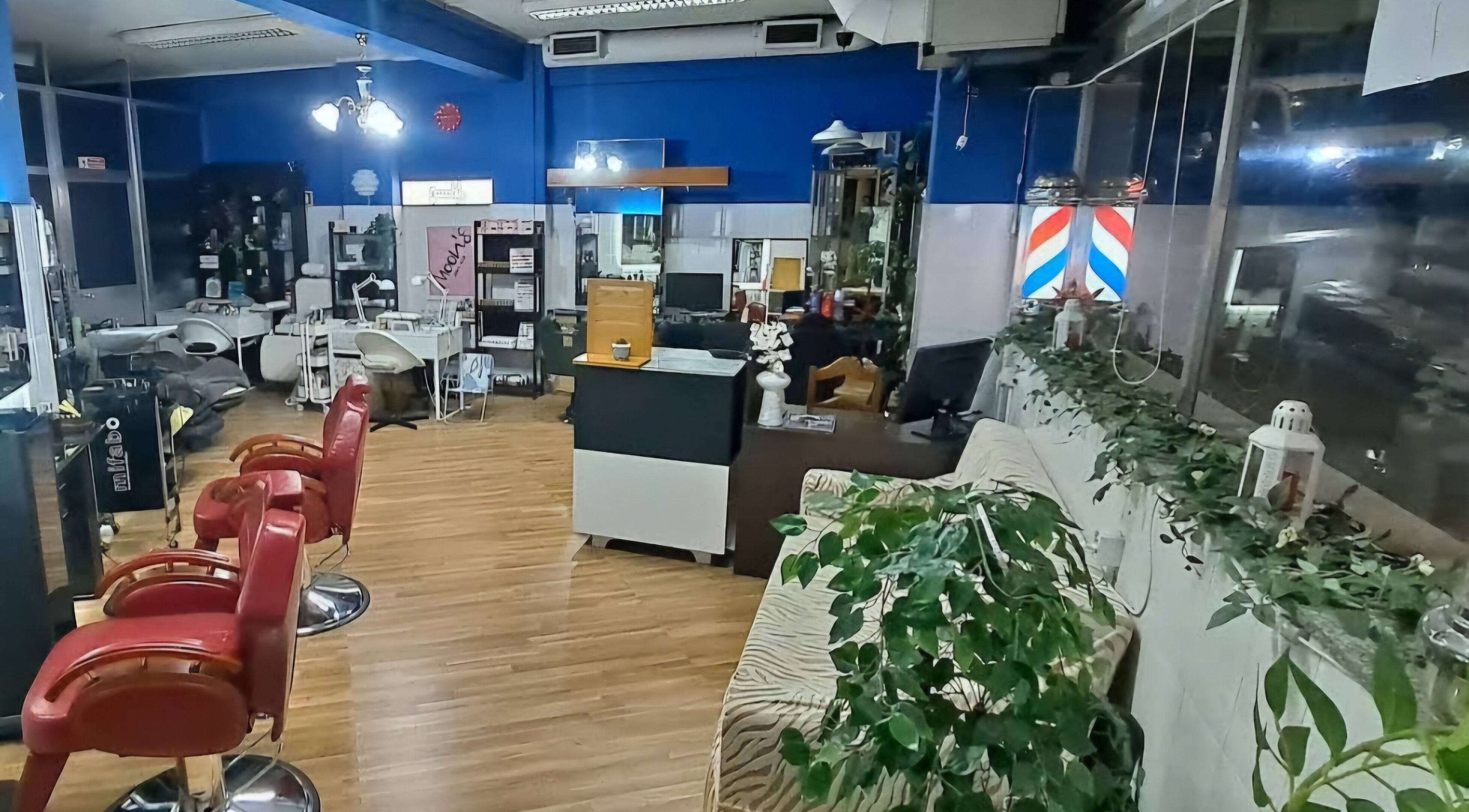 Interior moderno do Moon's nail bar em Porto, Porto, PT com cadeiras vermelhas e decoração luxuosa.