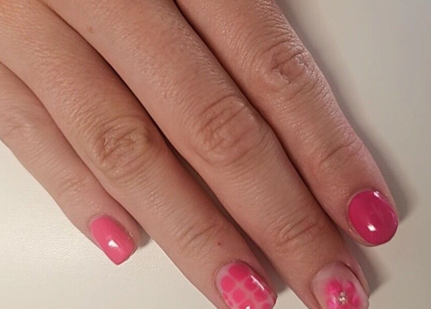 Stylish pink nails with floral art at Glowgetter Beauty, Holmes Chapel, England, GB.