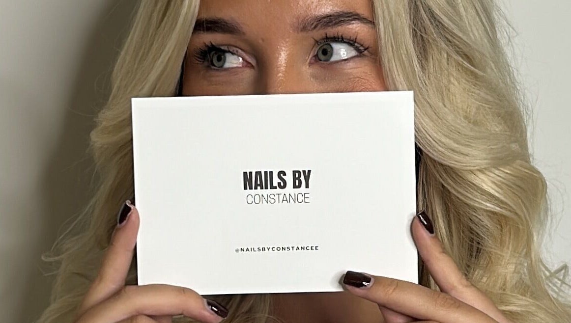 Person holding Nails by Constance card at Colwyn Bay, Wales, GB showcasing beauty services.