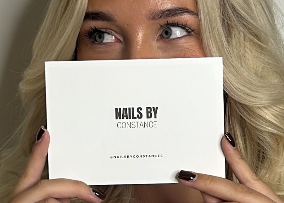 Person holding Nails by Constance card at Colwyn Bay, Wales, GB showcasing beauty services.