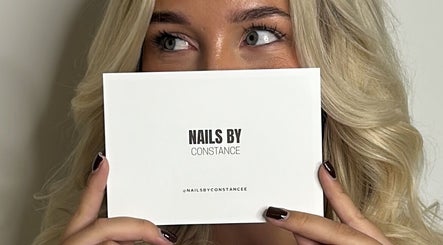 Person holding Nails by Constance card at Colwyn Bay, Wales, GB showcasing beauty services.
