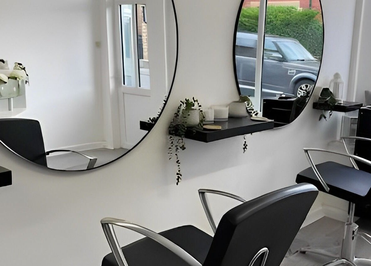 Modern salon interior at The Hideaway Salon, Malvern, England, GB with stylish chairs and mirrors.