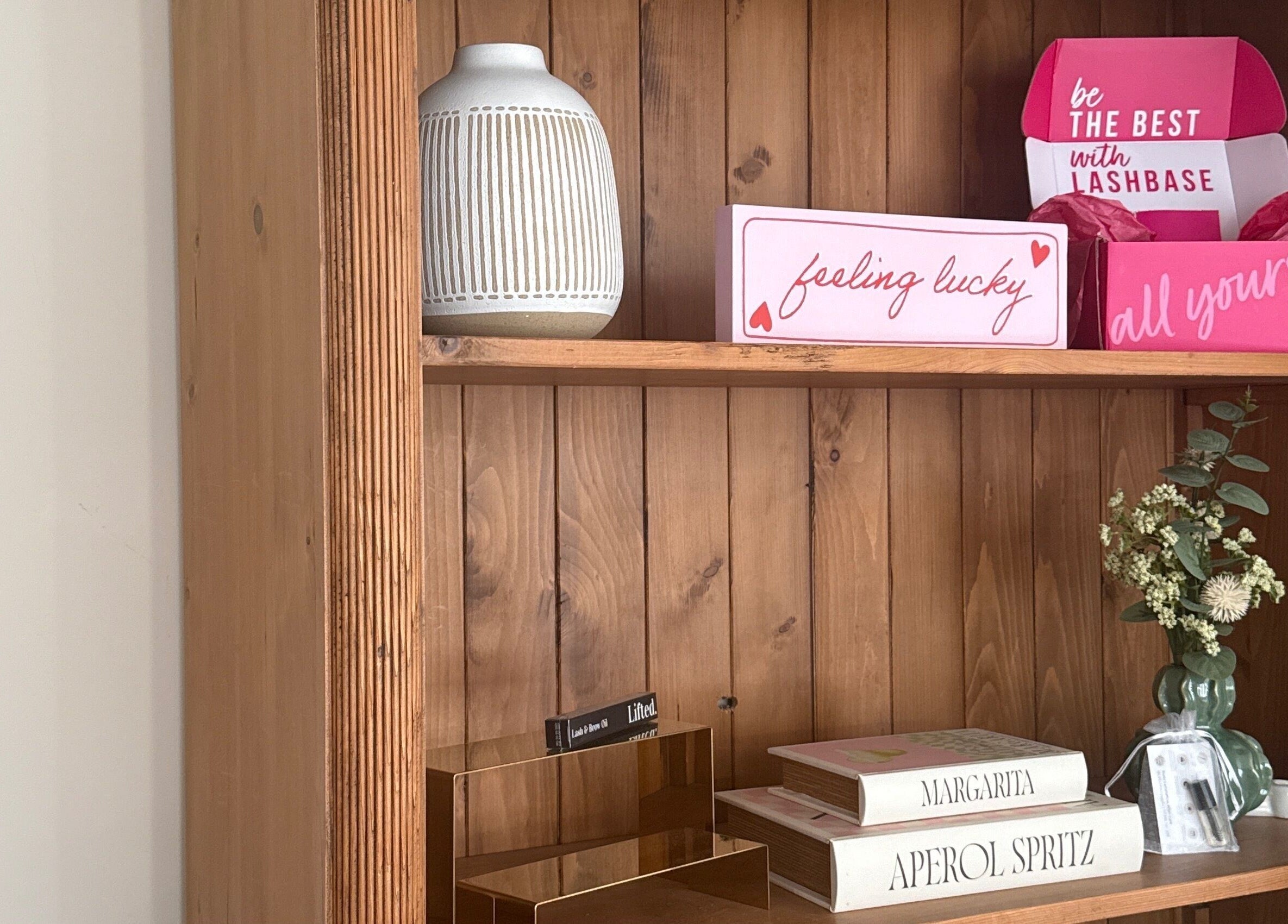 Decorative wooden shelf at Caits Beauty Spot in Barry, GB with beauty boxes and floral accents.
