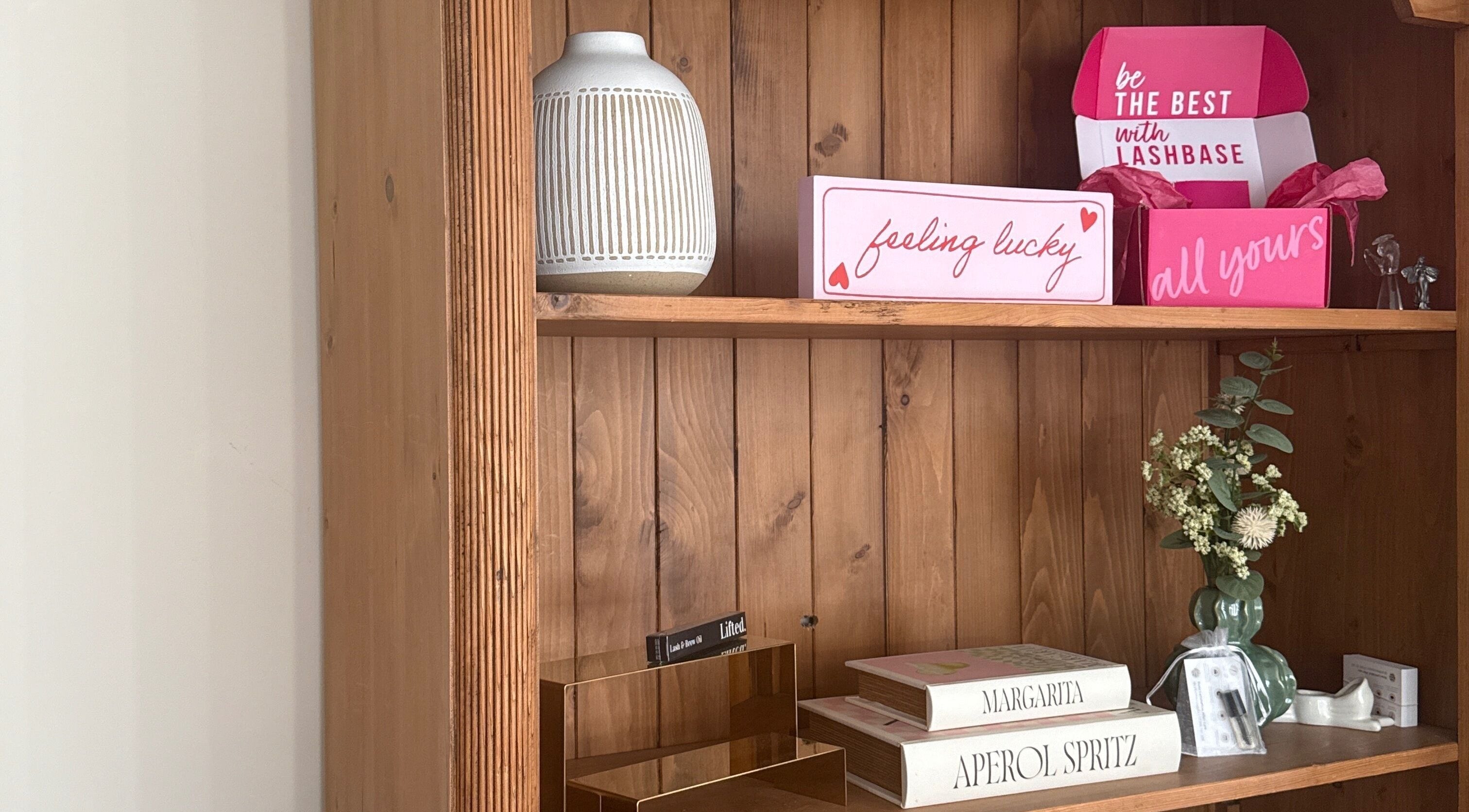 Decorative wooden shelf at Caits Beauty Spot in Barry, GB with beauty boxes and floral accents.