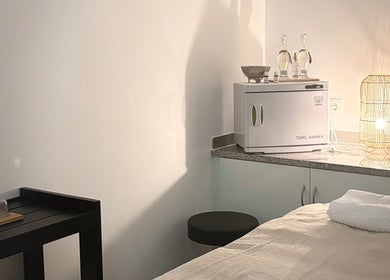 Sala de tratamento acolhedora no Vida Sense Spa, Ferragudo, Faro, PT, com aquecedor de toalhas e iluminação suave.
