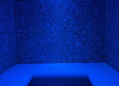 Sala de banho relaxante no Vida Sense Spa em Ferragudo, Faro, PT, com iluminação azul e paredes revestidas.