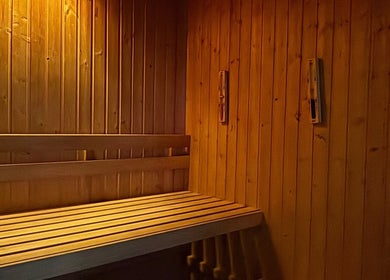 Interior de sauna aconchegante no Vida Sense Spa, Ferragudo, Faro, PT, destacando bancos de madeira e iluminação suave.