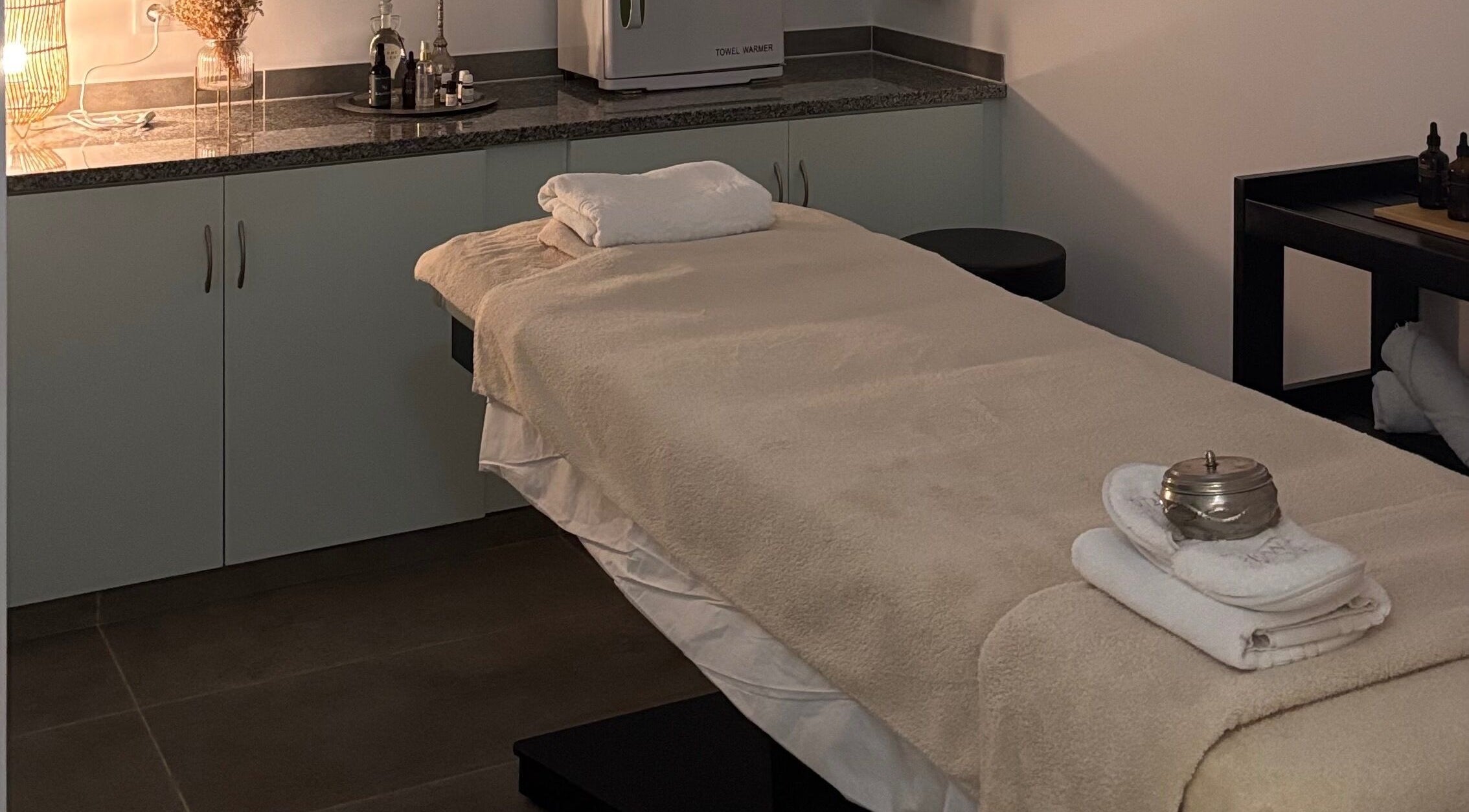 Sala de massagem aconchegante no Vida Sense Spa em Ferragudo, Faro, PT, pronta para tratamento relaxante.