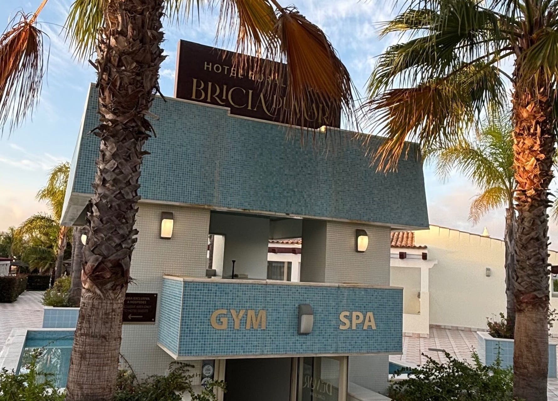 Entrada do spa Vida Sense Spa em Ferragudo, Faro, PT, rodeada por palmeiras ao entardecer.