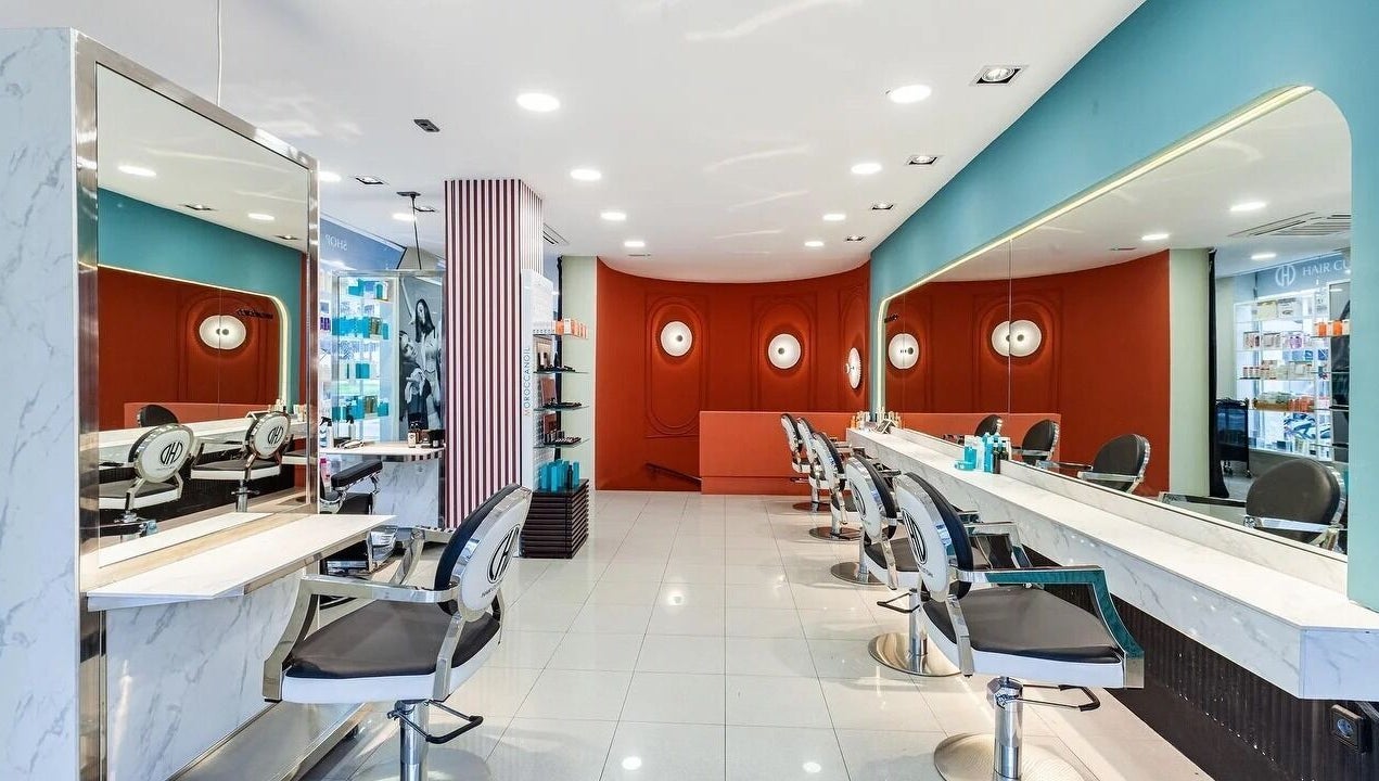 Salón moderno en Hair Cut Day Diagonal, Barcelona, Catalunya, ES, destacando sillas elegantes y decoración vibrante.