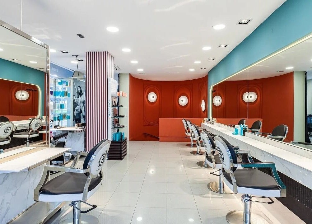 Salón moderno en Hair Cut Day Diagonal, Barcelona, Catalunya, ES, destacando sillas elegantes y decoración vibrante.
