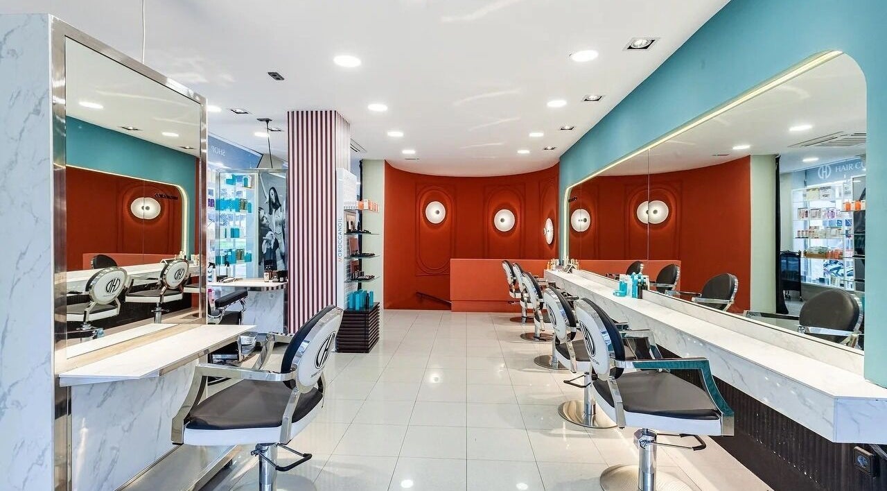 Salón moderno en Hair Cut Day Diagonal, Barcelona, Catalunya, ES, destacando sillas elegantes y decoración vibrante.