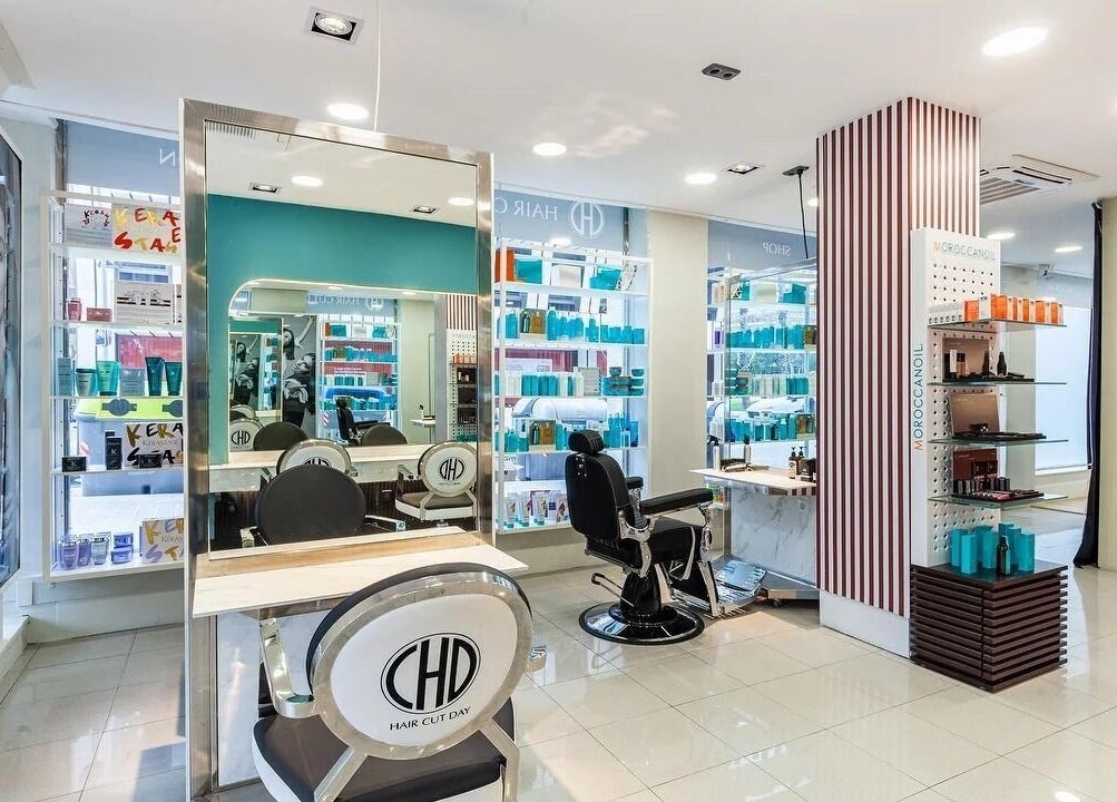 Interior moderno de Hair Cut Day Diagonal, Barcelona, Catalunya, ES, con espejos y productos capilares.