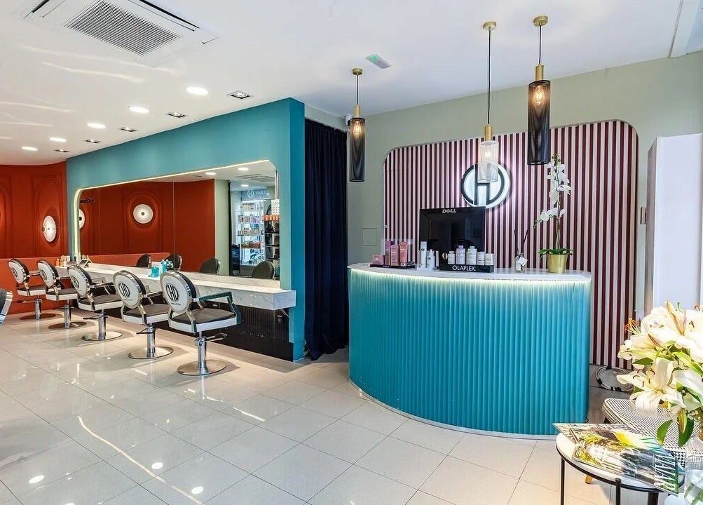 Interior moderno del salón Hair Cut Day Diagonal en Barcelona, Catalunya, ES. Sillas y recepción elegantes.