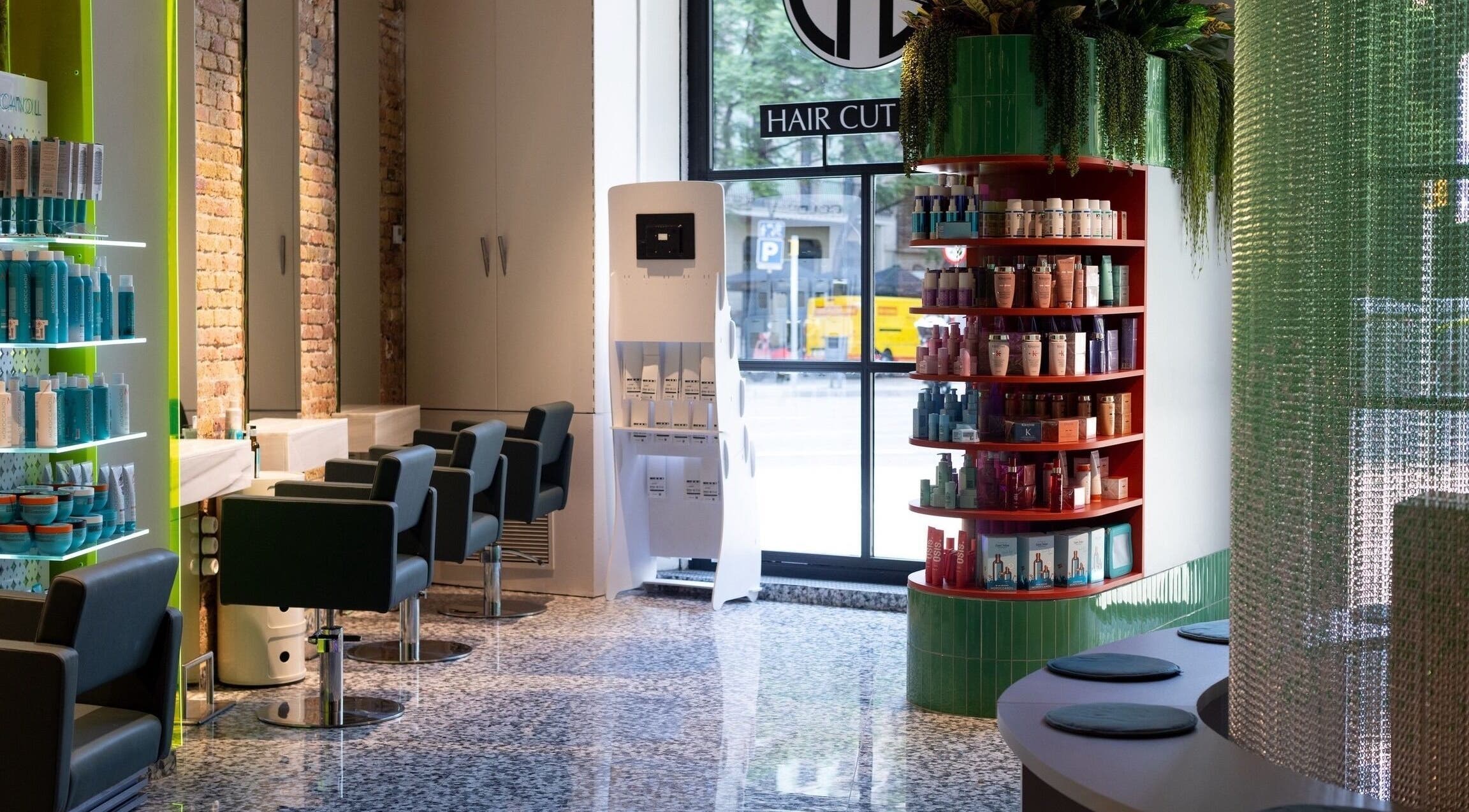 Interior moderno de Hair Cut Day Letamendi, Barcelona, Catalunya, ES con sillas de peluquería y estantes de productos.