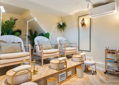 Área de pedicura en La Esmaltería Barcelona, con sillones cómodos y decoraciones elegantes en Barcelona, Catalunya, ES.
