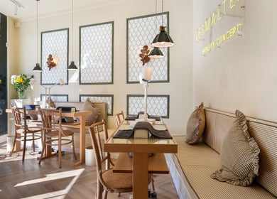 Interior de La Esmaltería Barcelona en Barcelona, Catalunya, ES, con mesas de madera y plantas decorativas.