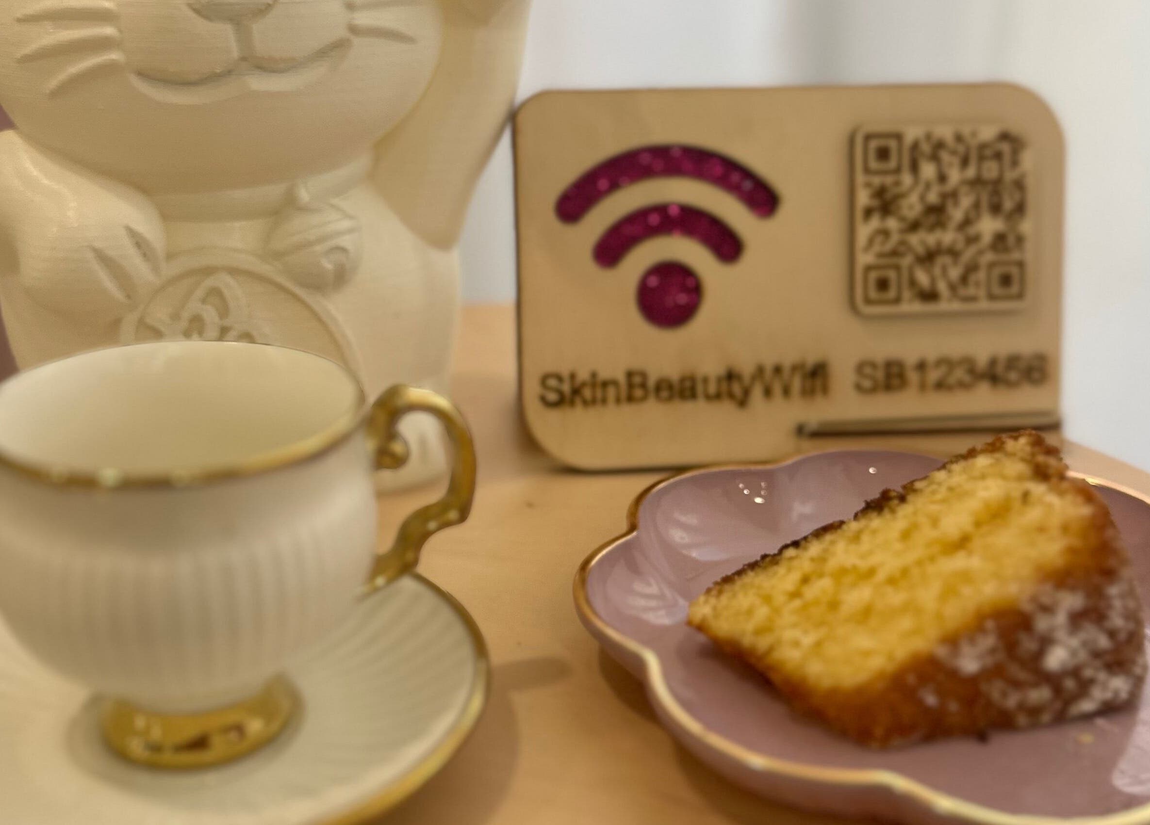 Chávena de chá e bolo em Teresa Coelho, Portimão, Faro, PT, com placa de Wi-Fi moderno.